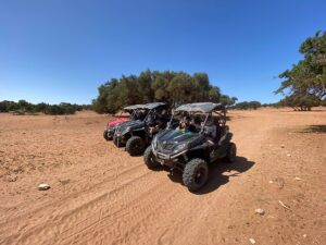 Trois quads prêts pour une aventure tout-terrain dans la périphérie ensoleillée et sablonneuse d’Agadir.
